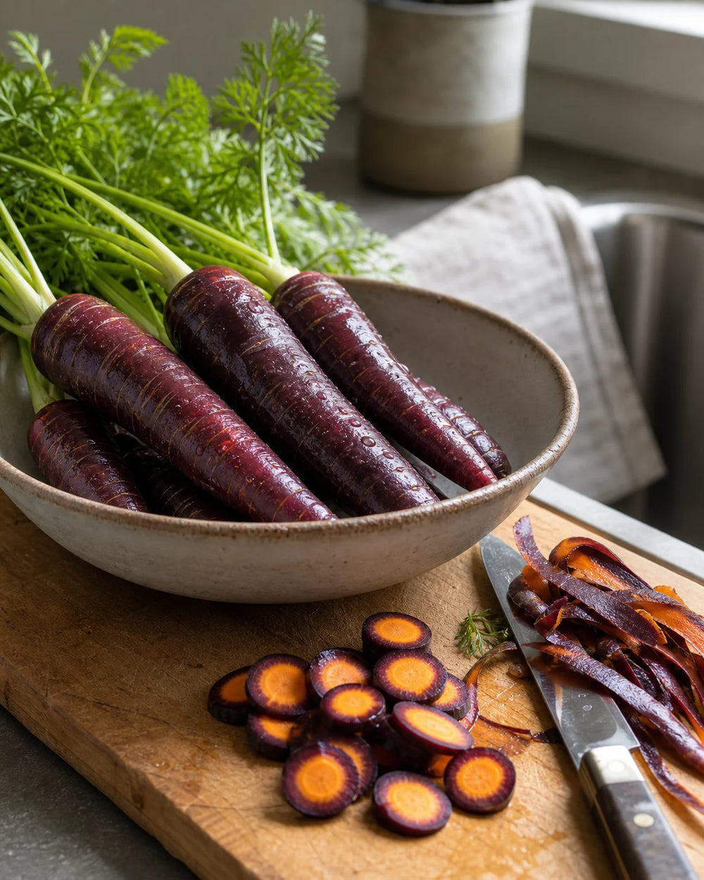 Cosmic Purple carrots prepared for salad and roasting on a kitchen board