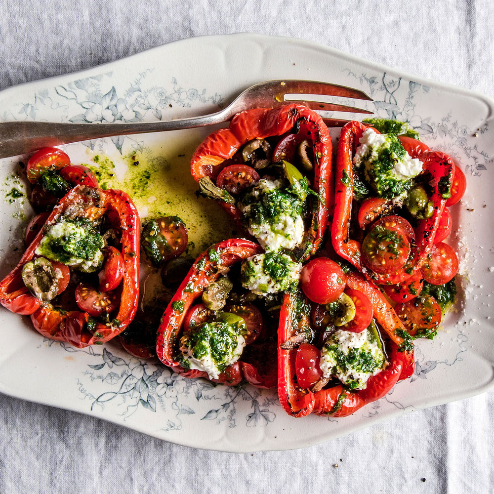 Stuffed Criolle de Cocina peppers with a green herb mixture on a decorative plate with a fork.