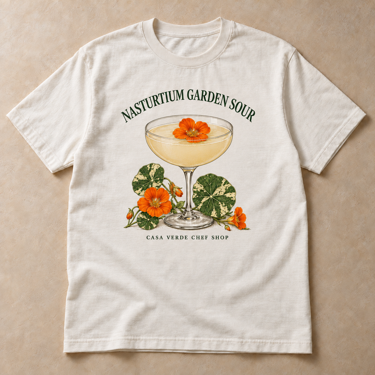 Nasturtium Garden Sour T-Shirt — approved individual front design preview with an illustrated coupe, orange nasturtium flowers and variegated leaves and the Casa Verde Chef Shop signature. Illustrative garment mockup, not a production master.