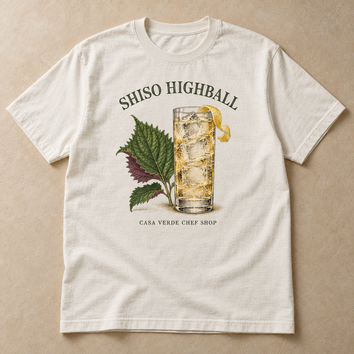 Shiso Highball T-Shirt — approved front preview with a tall glass, ice, lemon peel, green and purple shiso leaves, title and Casa Verde Chef Shop signature.