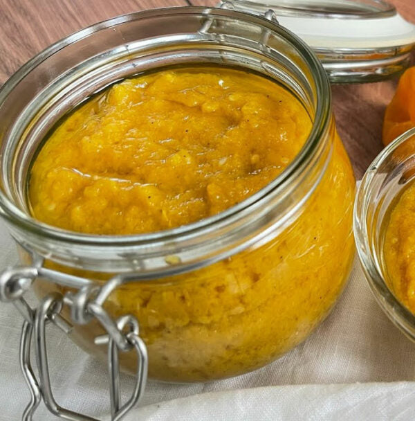 Jar of yellow preserve with a metal clasp on a wooden surface