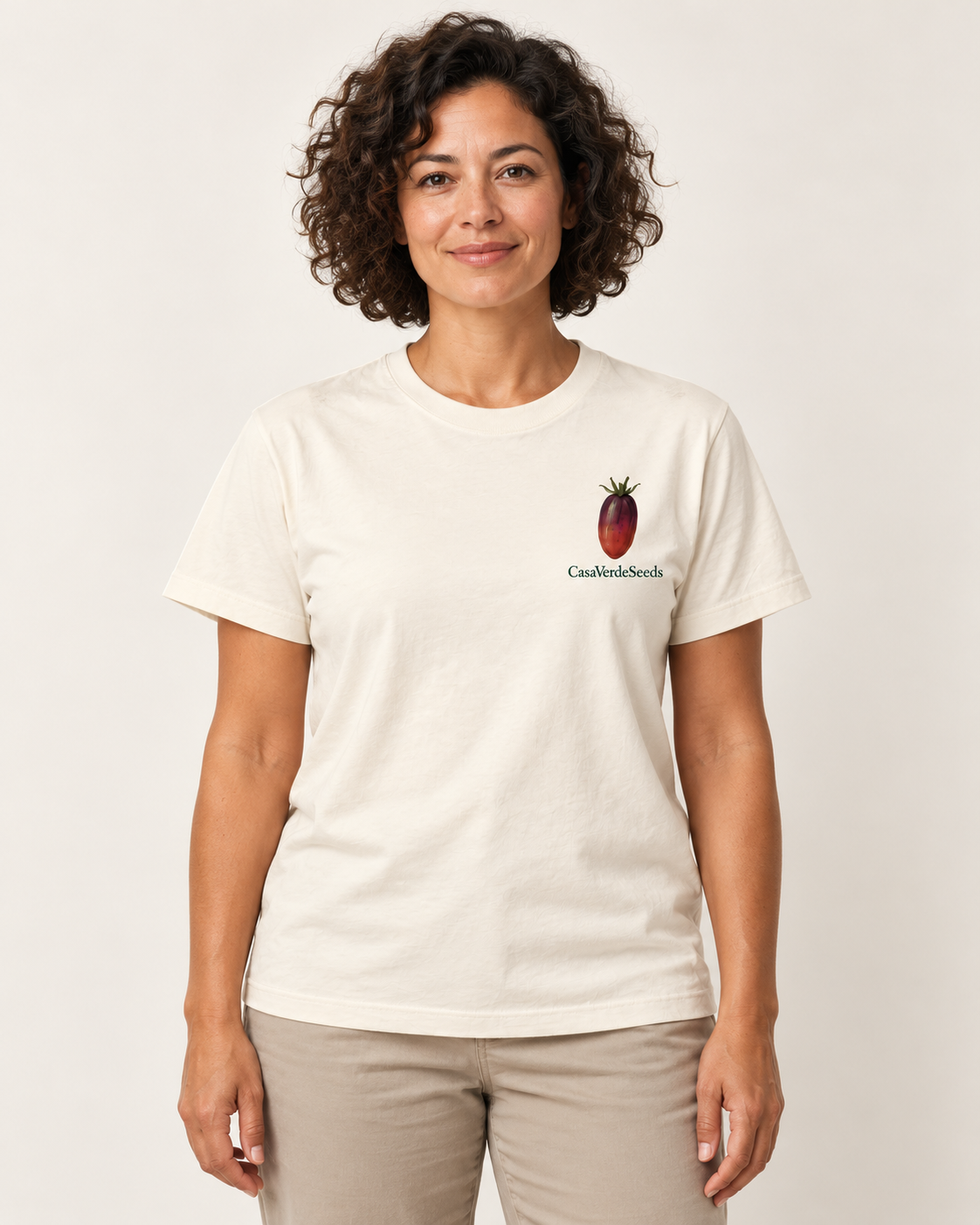 Tomato Obsessed T-Shirt — front shown on a model, with a small dark tomato and Casa Verde Seeds signature at the left chest. Illustrative garment preview; final fit and print placement may vary.